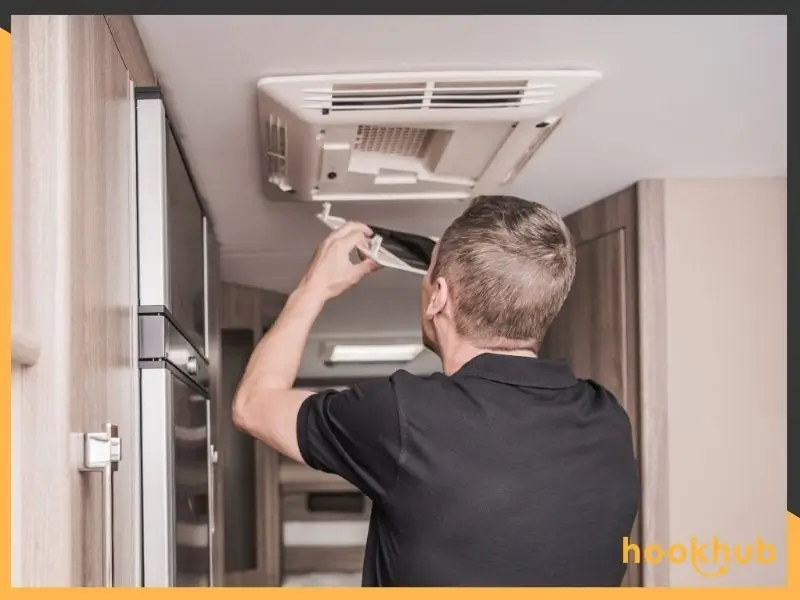 A person cleaning the RV air conditioner filter