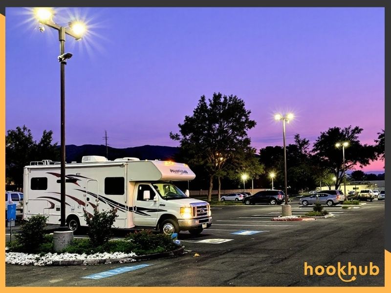 RV parked in a well-lit lot with security cameras visible