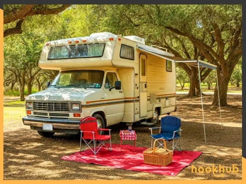 RV with awning extended under shade of trees