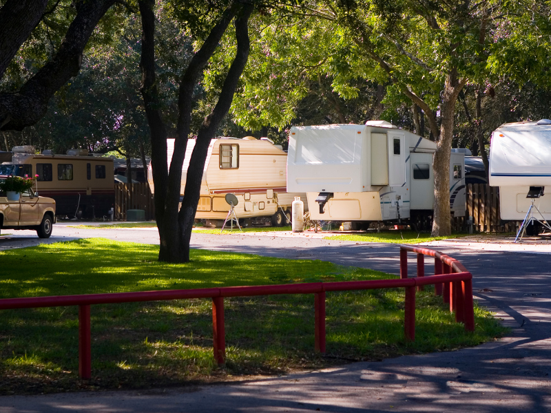 Shaded outdoor RV storage area with multiple motorhomes parked
